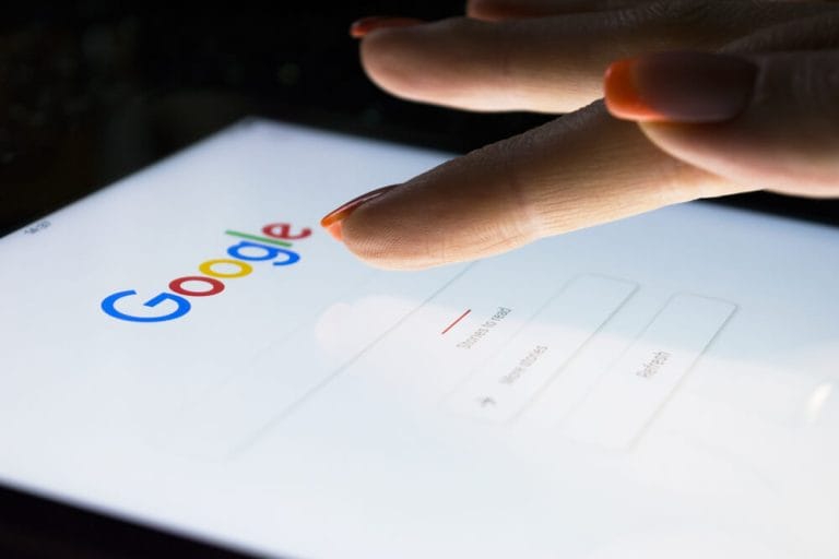 Woman performing Google search on tablet.
