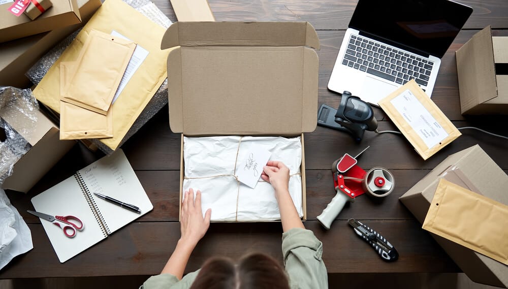 Small business owner packaging up items and preparing for shipping.