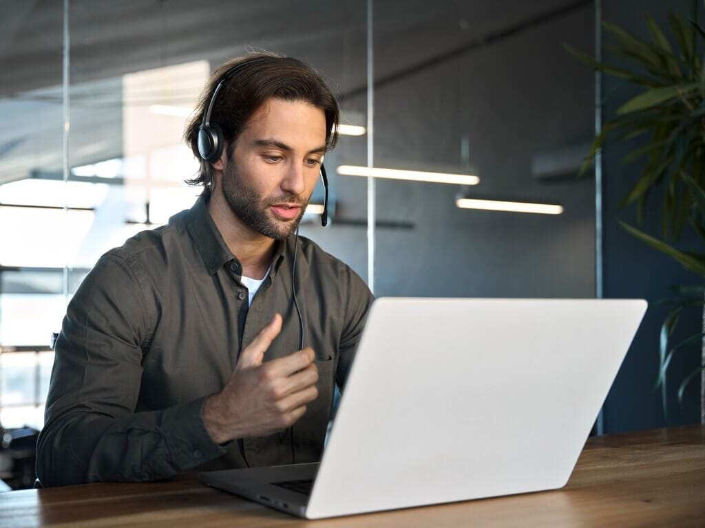 WordPress expert providing virtual support during a client call from a modern office.