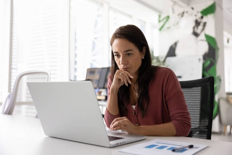 Business owner reviewing information on a laptop before hiring a web designer